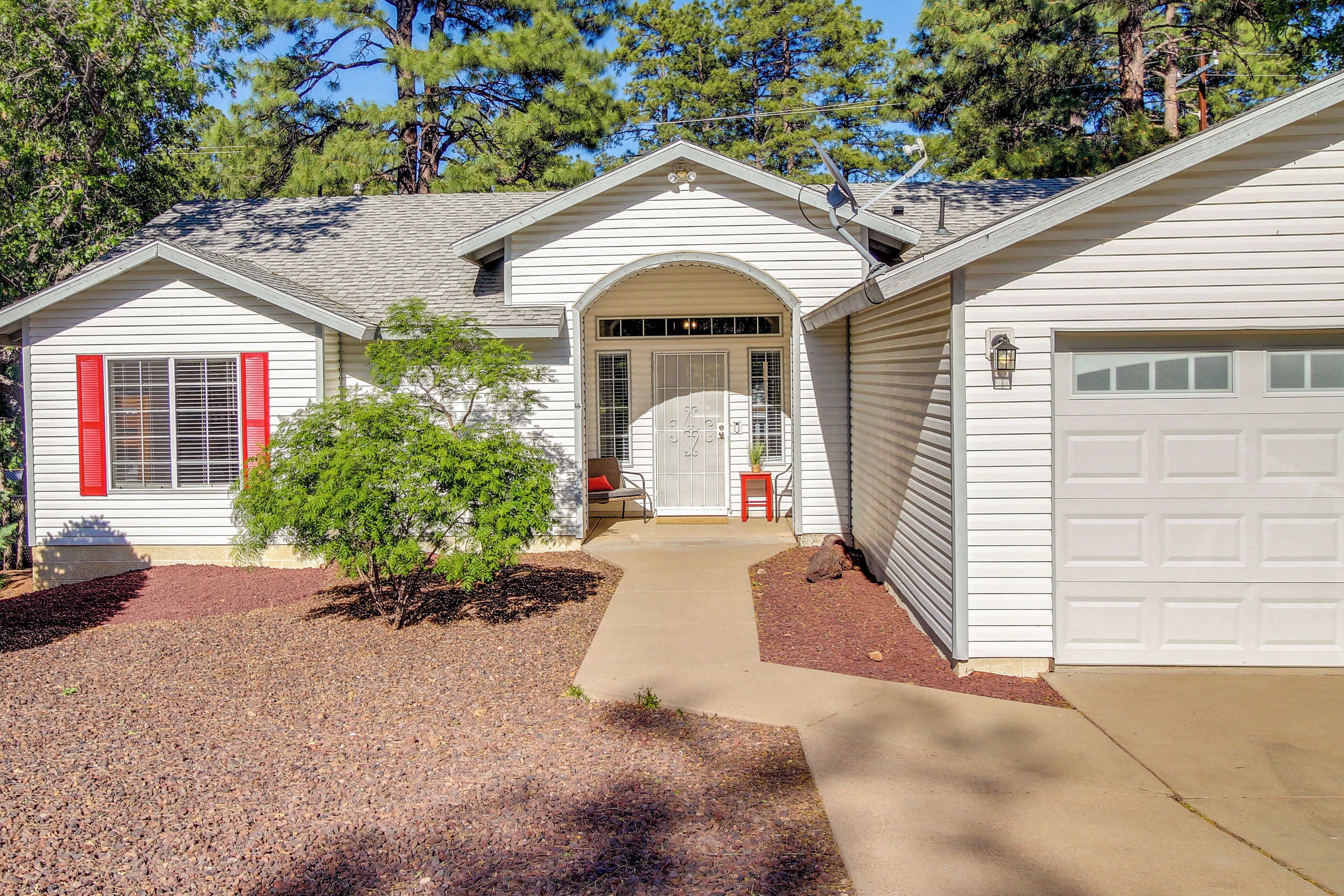 A two-story house with a front porch, a garage, and a small garden area.