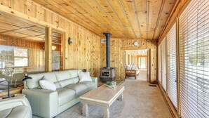 A cozy cabin interior with a sofa, coffee table, and a wood-burning stove. - Spacious Coarsegold Getaway ~ 34 Mi to Yosemite! (Coarsegold)