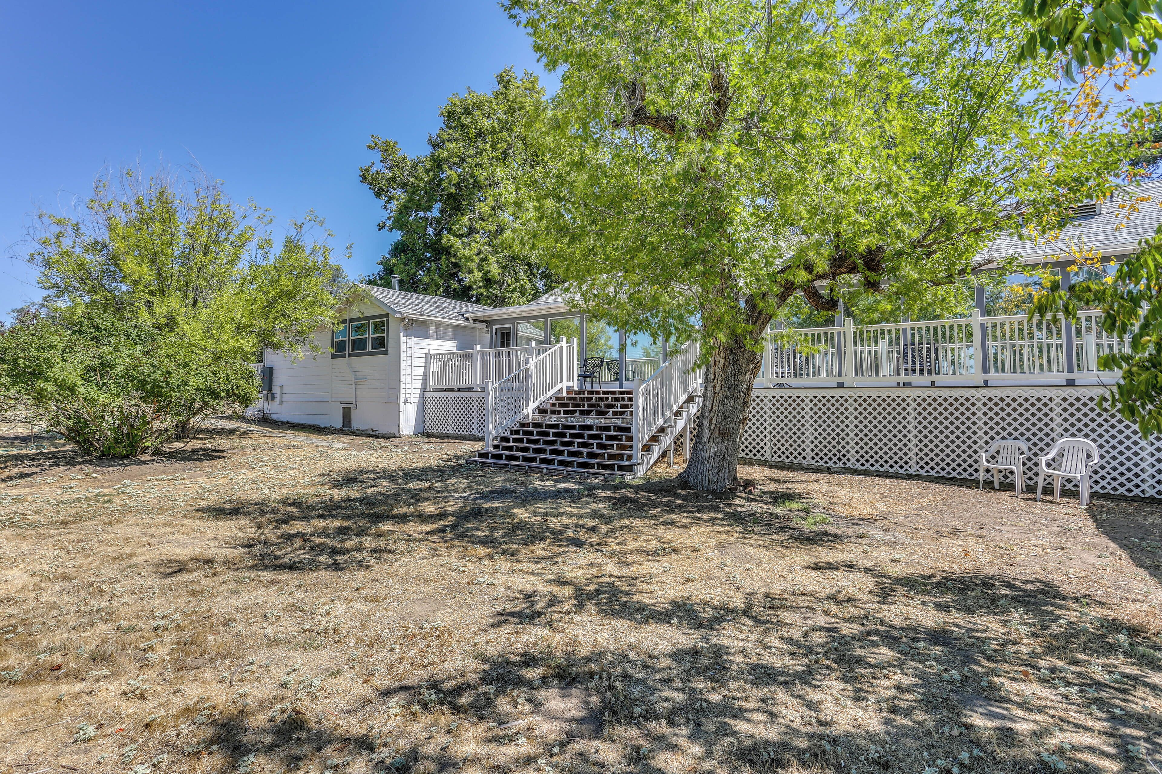 A white house with a covered porch and a fenced deck.