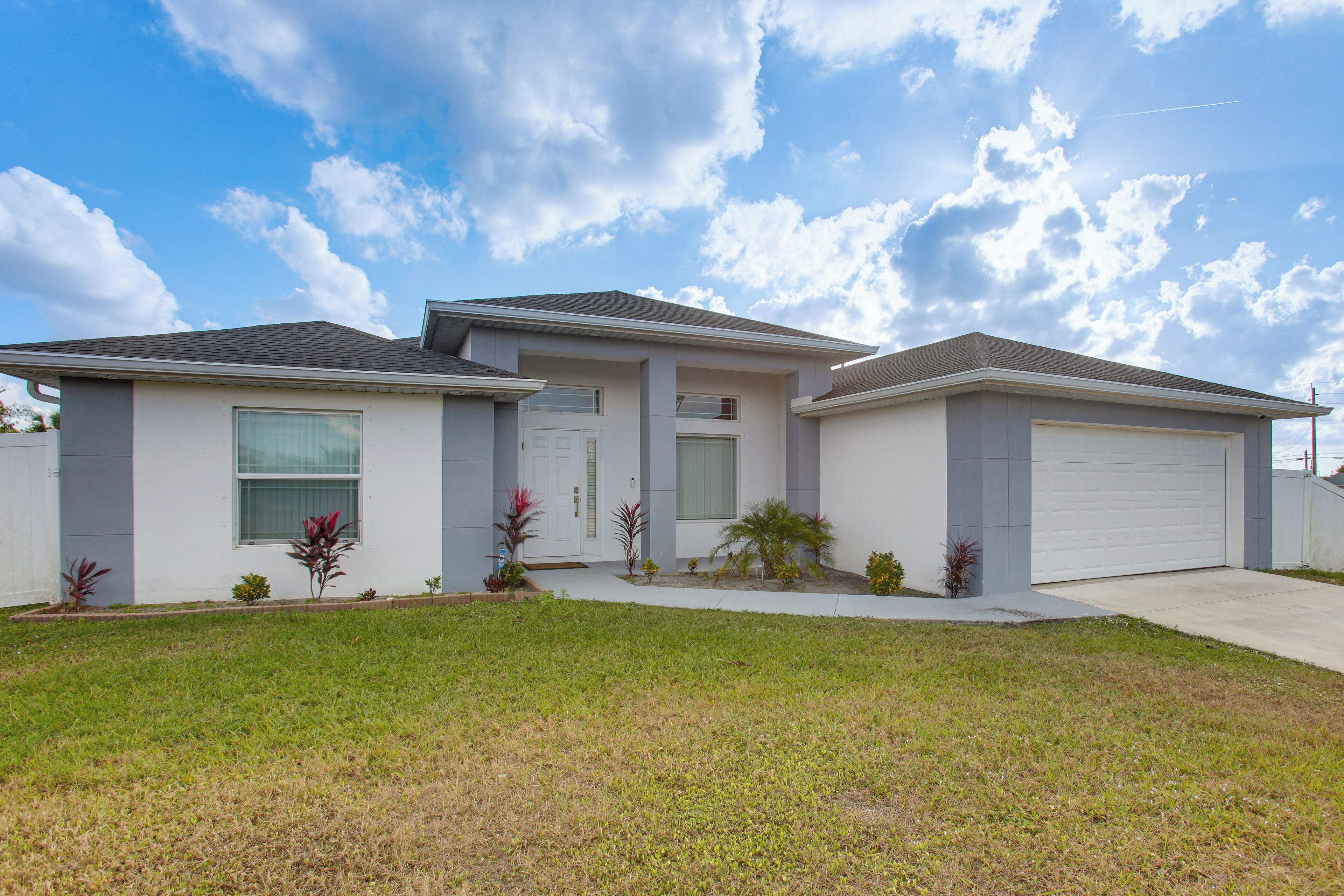 A two-story house with a garage, a front porch, and a well-maintained lawn.