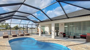 A covered outdoor swimming pool with lounge chairs and a patio area. - Furnished Lanai & Yard: Comfy Lehigh Acres Getaway (Lehigh Acres)