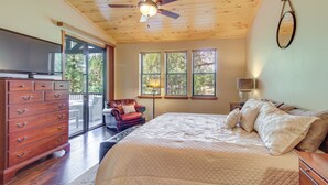 Une chambre à coucher avec un grand lit, un plafond en bois et un ventilateur de plafond.