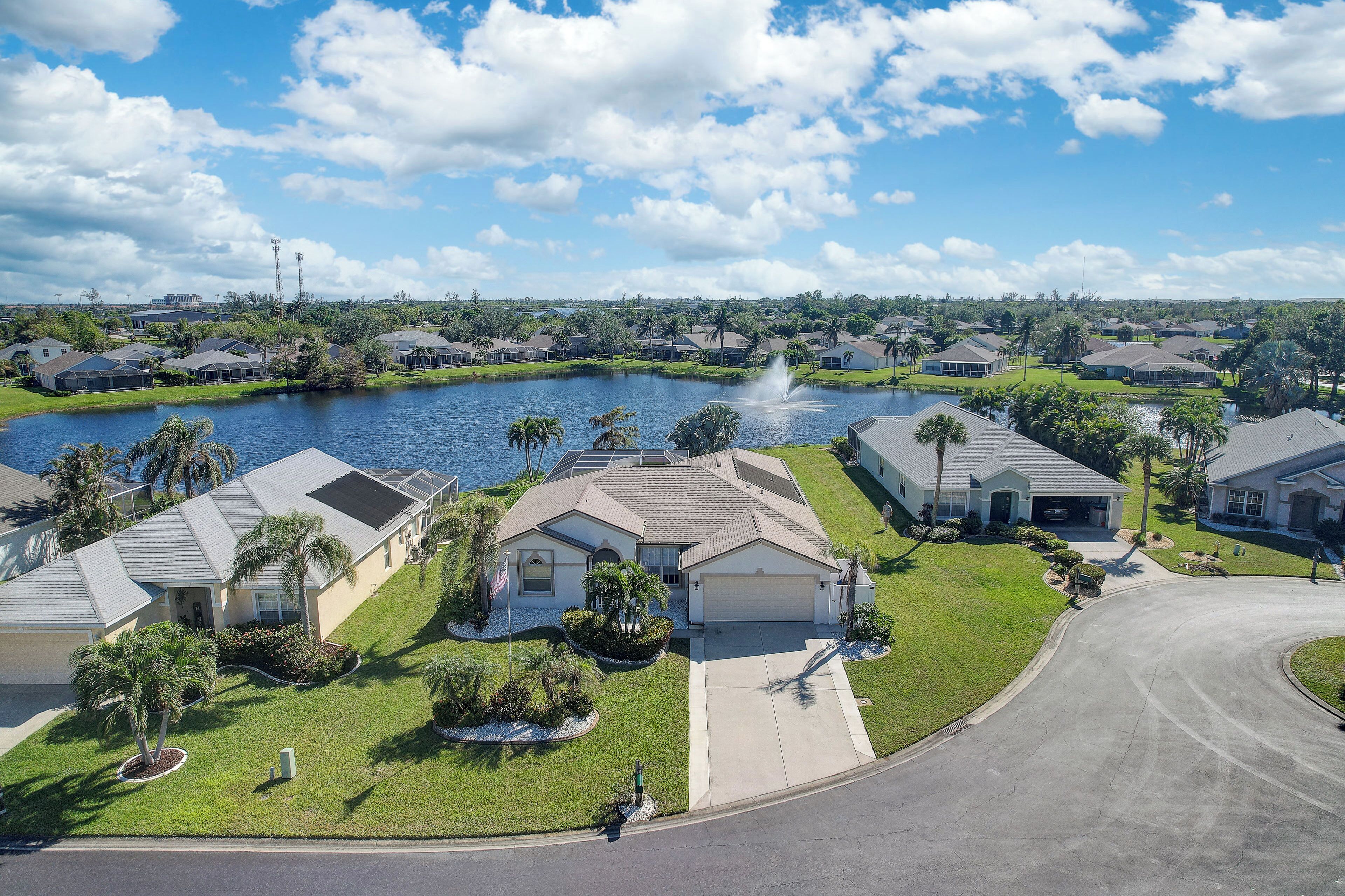 A residential area with houses, a lake, and a fountain.