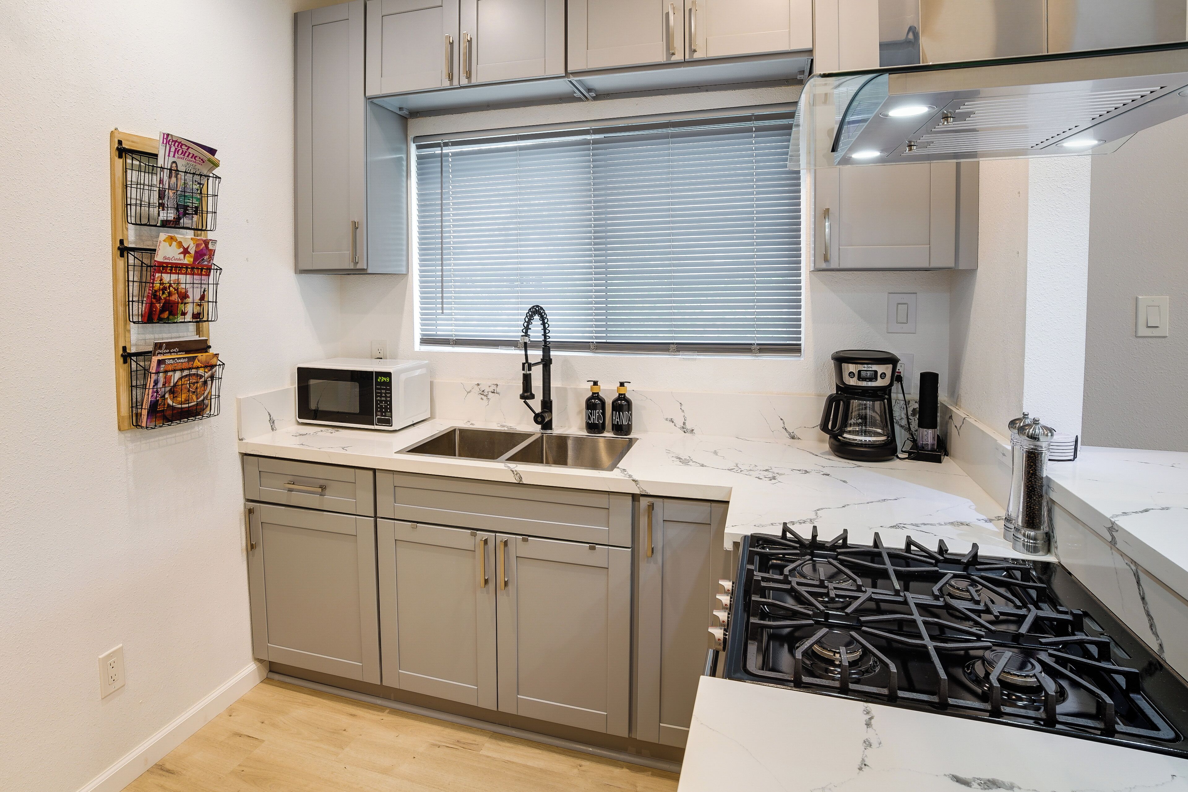 A modern kitchen with a double sink, stainless steel appliances, and a gas stove.