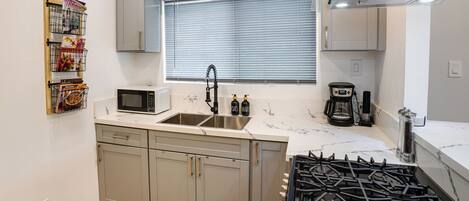 A modern kitchen with a double sink, stainless steel appliances, and a gas stove.