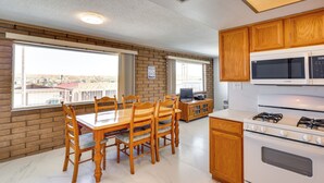 A modern kitchen with a dining area, large windows, and a view of the city. - Riverfront Bullhead City Home w/ Mountain Views! (Bullhead City)