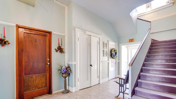 A hallway with a wooden door, white doors, a bench, and a purple staircase. - Downtown Schertz Vacation Rental Near Restaurants! (Schertz)