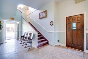 A staircase with a red handrail leading to a landing with a door marked "EXIT".
