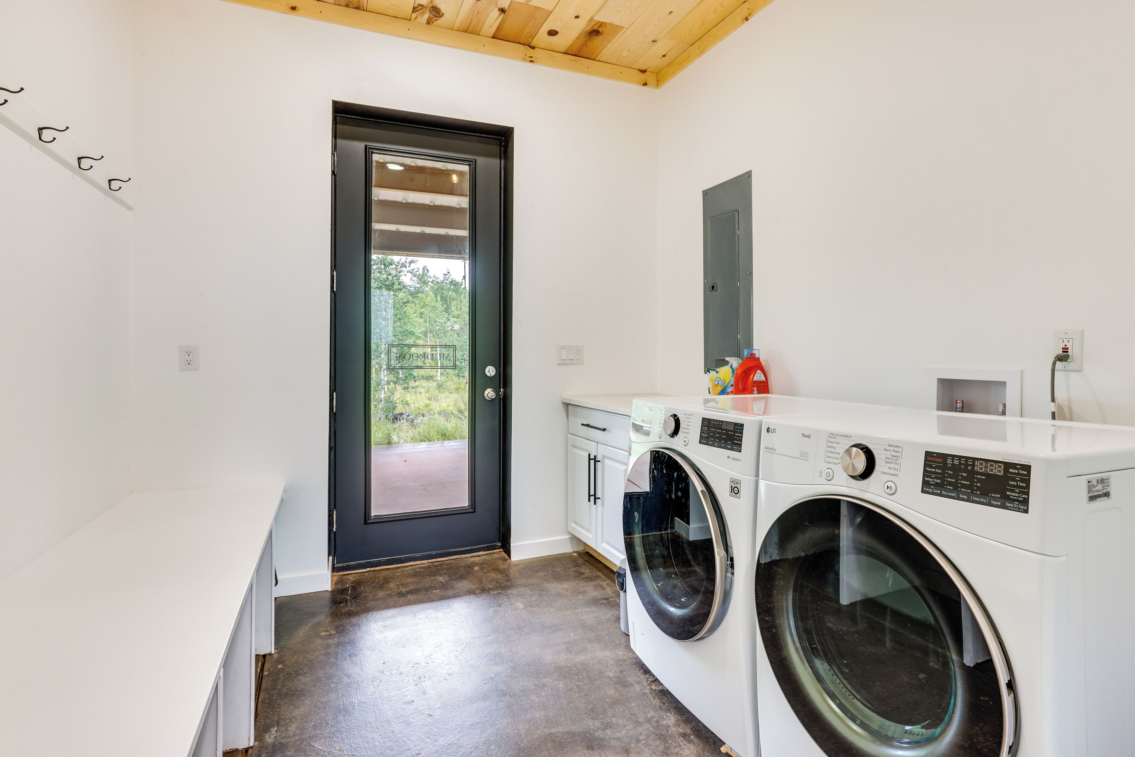 A laundry room with a washing machine, a dryer, and a small cabinet.