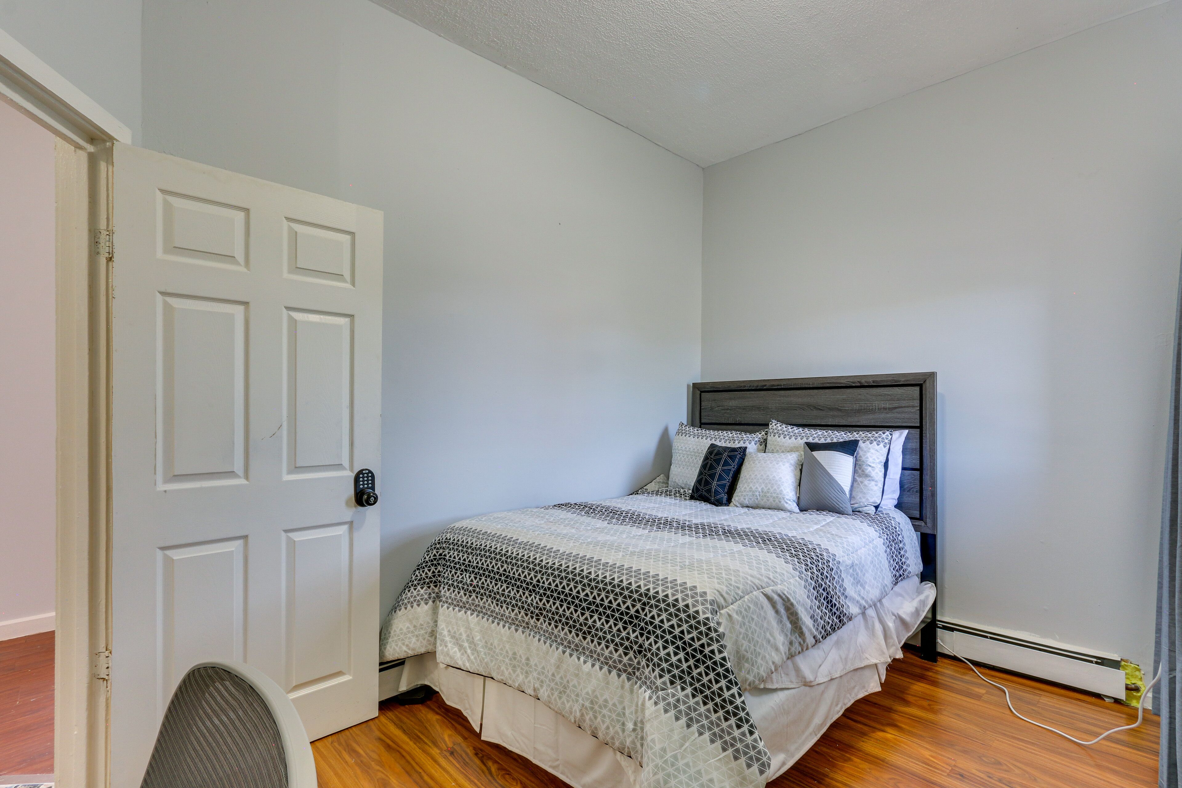 Une chambre à coucher avec un lit, une chaise et une porte.