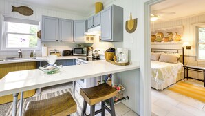 A kitchen with white cabinets, a large island, and a dining area. - Riverfront Florida Escape w/ Grill & Fire Pit! (Tallahassee)
