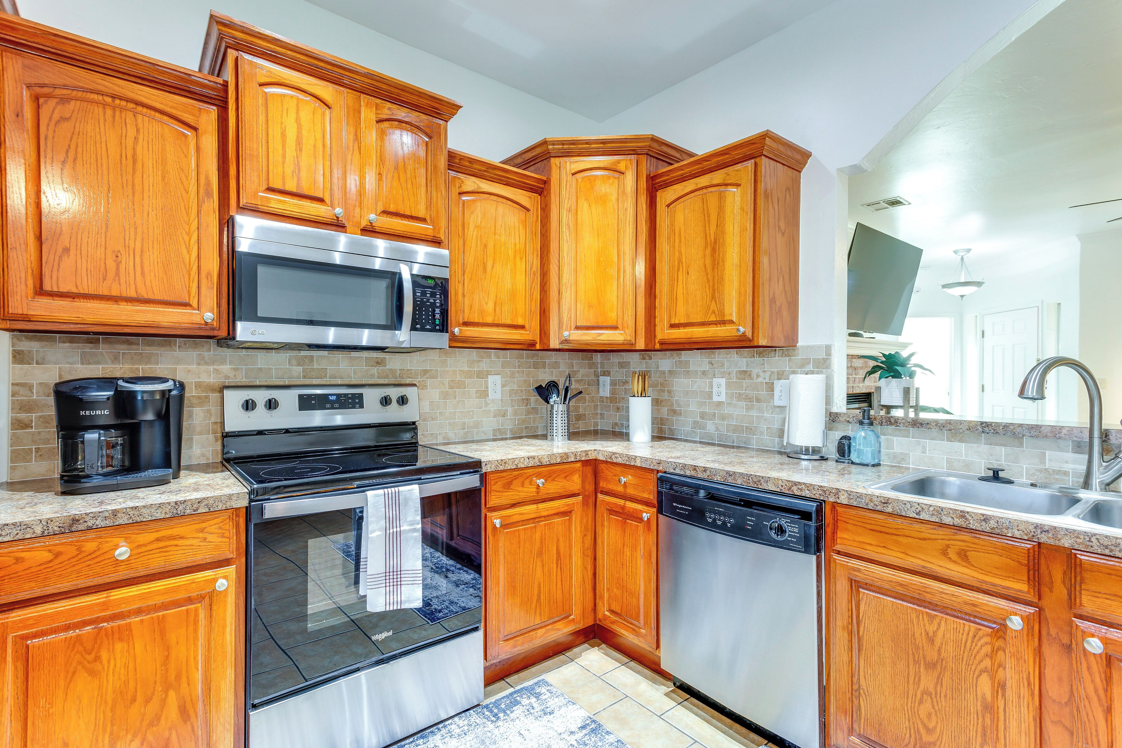 A kitchen with wooden cabinets, stainless steel appliances, and a granite countertop.