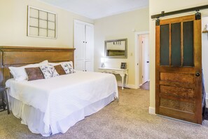 A bedroom with a large bed, a desk, a wardrobe, and a sliding door. - Jefferson City Getaway - 3 Mi to Cherokee Lake! (Jefferson City)