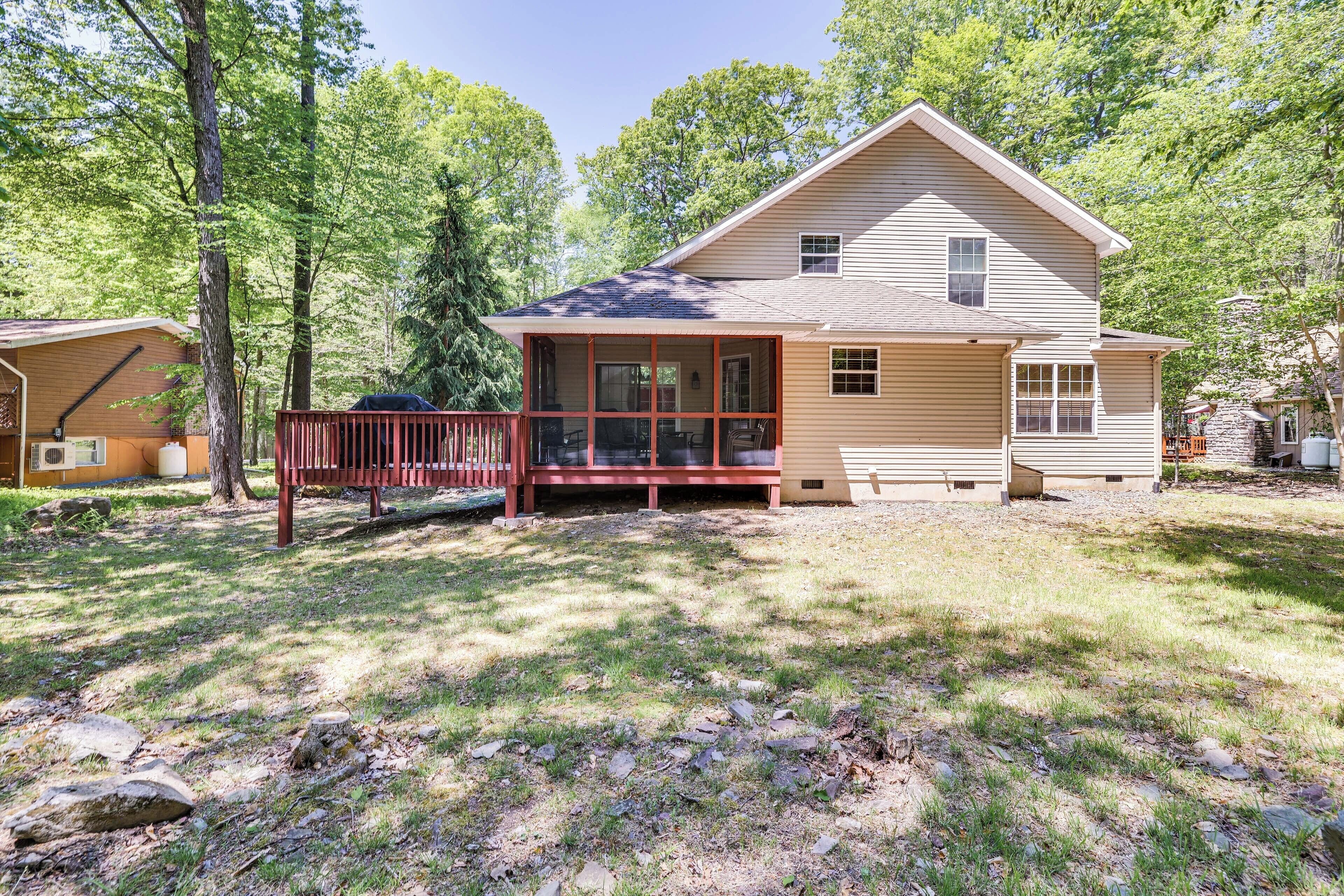 A two-story house with a covered porch and a fenced yard.