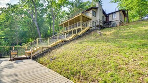 A house with a wooden deck and a staircase leading to a second-story balcony. - Waterfront Home w/ Views & Dock in Sunrise Beach! (Sunrise Beach)