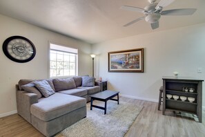 Relax in this stylish living room with a sofa, ottoman, coffee table, and floor lamp.