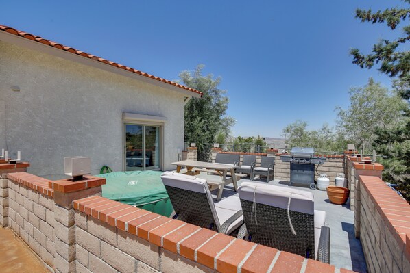 A patio with outdoor furniture, a grill, and a view of the surrounding landscape. - California Vacation Rental With Hot Tub & Patio! (Yucca Valley)