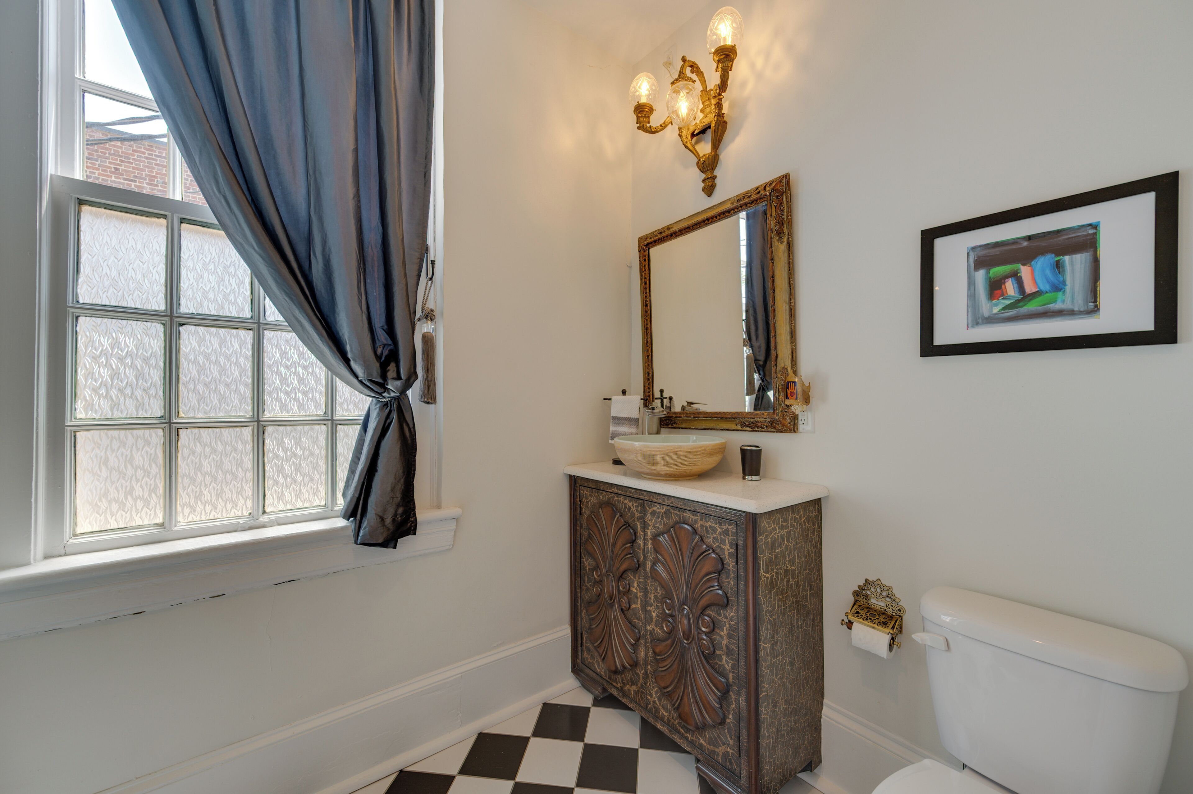 A bathroom with a white sink, a mirror, and a toilet.