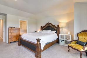Quarto com cama de madeira, cômoda, penteadeira e uma cadeira.