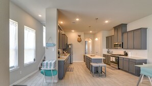 A modern kitchen with grey cabinets, a central island, and a hanging deer head decoration. - La Porte Home w/ Balconies: Walk to Beach! (La Porte)