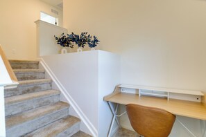 A staircase with carpeted steps leading to a landing. A wooden desk with a chair is positioned on the landing. - Unwind & Explore the City! Convenient Aurora Home (Aurora)