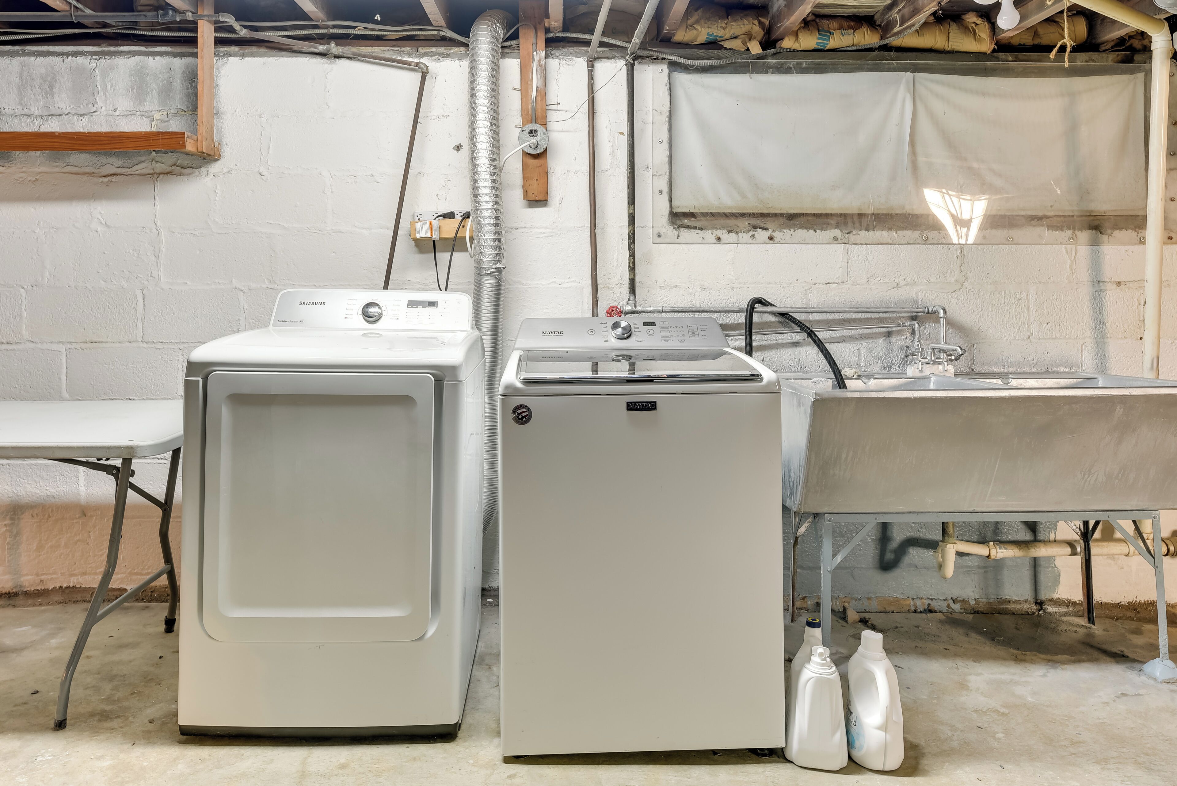 A laundry area with a washing machine, dryer, and sink.