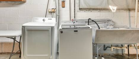 A laundry area with a washing machine, dryer, and sink.