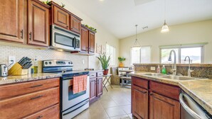 A kitchen with wooden cabinets, a built-in microwave, an oven, and a sink. - Mesquite Vacation Rental - Close to Golf Courses! (Mesquite)