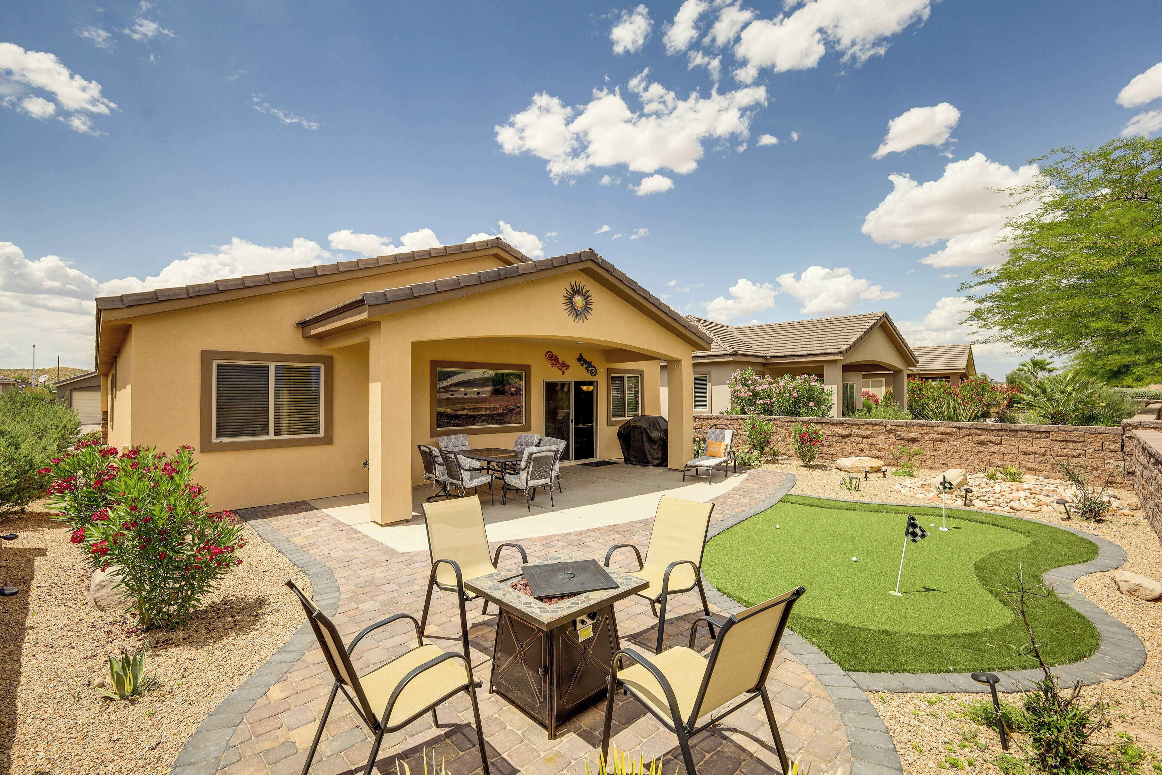 A residential property with a patio, outdoor seating, and a putting green.