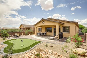 Ein Wohnhaus mit Terrasse, Rasen und kleinem Garten.