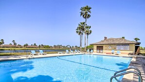 A swimming pool with lounge chairs and a lifeguard station. - Swim, Golf & Unwind: Laguna Vista Vacation Home! (Port Isabel)