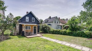 A residential property with a well-maintained lawn, a wooden deck, and a stone pathway leading to the front door.