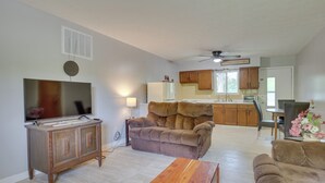 A living room with a TV, sofa, and wooden coffee table. - Cozy Youngstown Apartment w/ Central A/C + Heating (Poland)