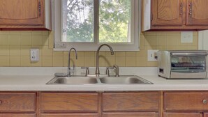 A kitchen with wooden cabinets, a double sink, and a built-in microwave. - Cozy Youngstown Apartment w/ Central A/C + Heating (Poland)