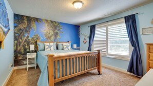 Quarto com cama de madeira, mesa de cabeceira, painel decorativo na parede, janela com cortinas e luminária no teto.