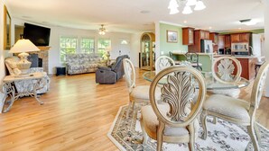 A spacious living room with a fireplace, a sofa, and a dining area with ornate chairs. - Hendersonville Retreat w/ Mtn Views & Deck! (Hendersonville)