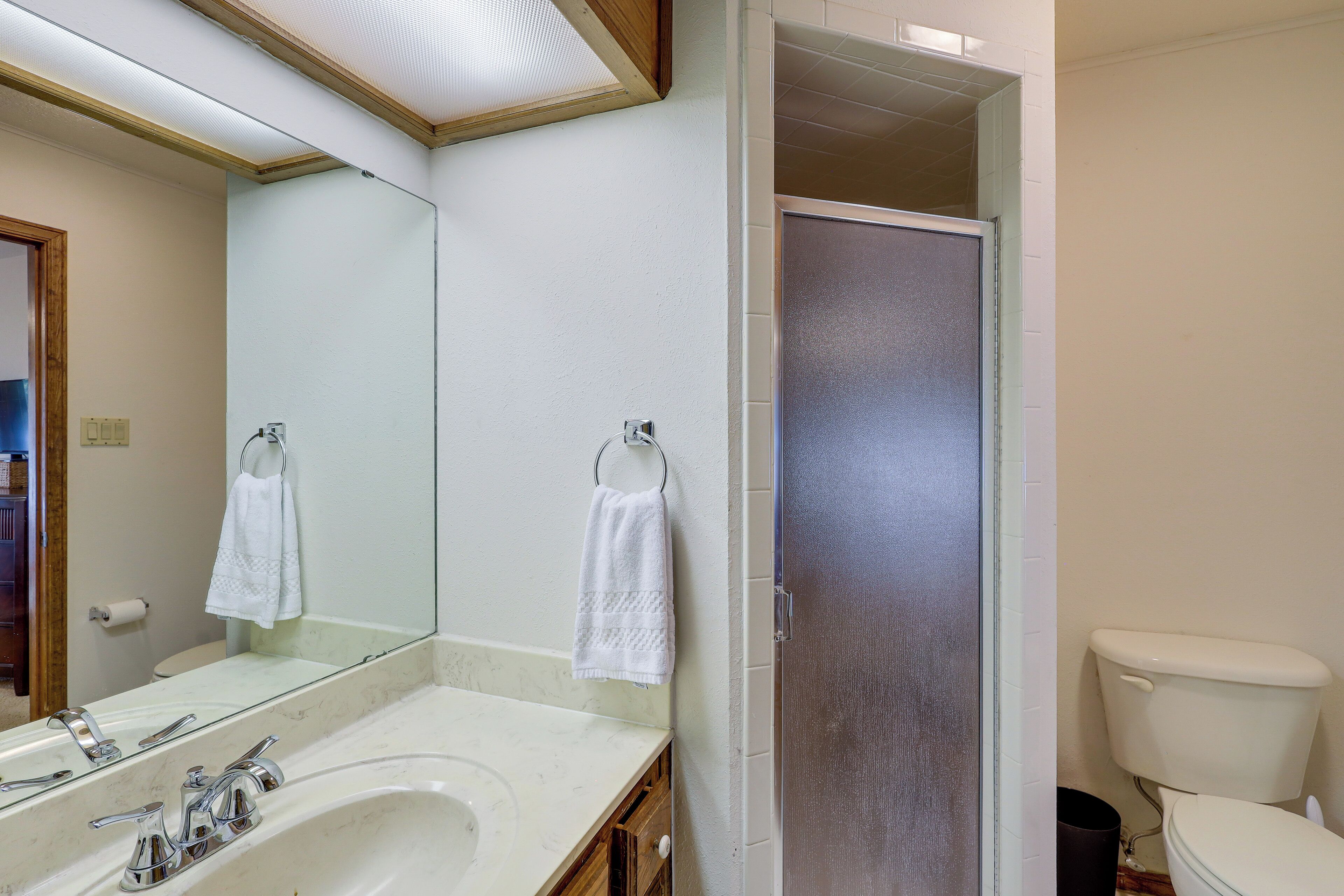 A bathroom with a sink, mirror, towel rack, and toilet.