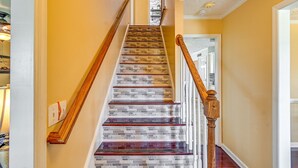 A staircase with a brick pattern design and wooden handrails. - Roomy Fayetteville Home Rental w/ Screened Porch! (Fayetteville)