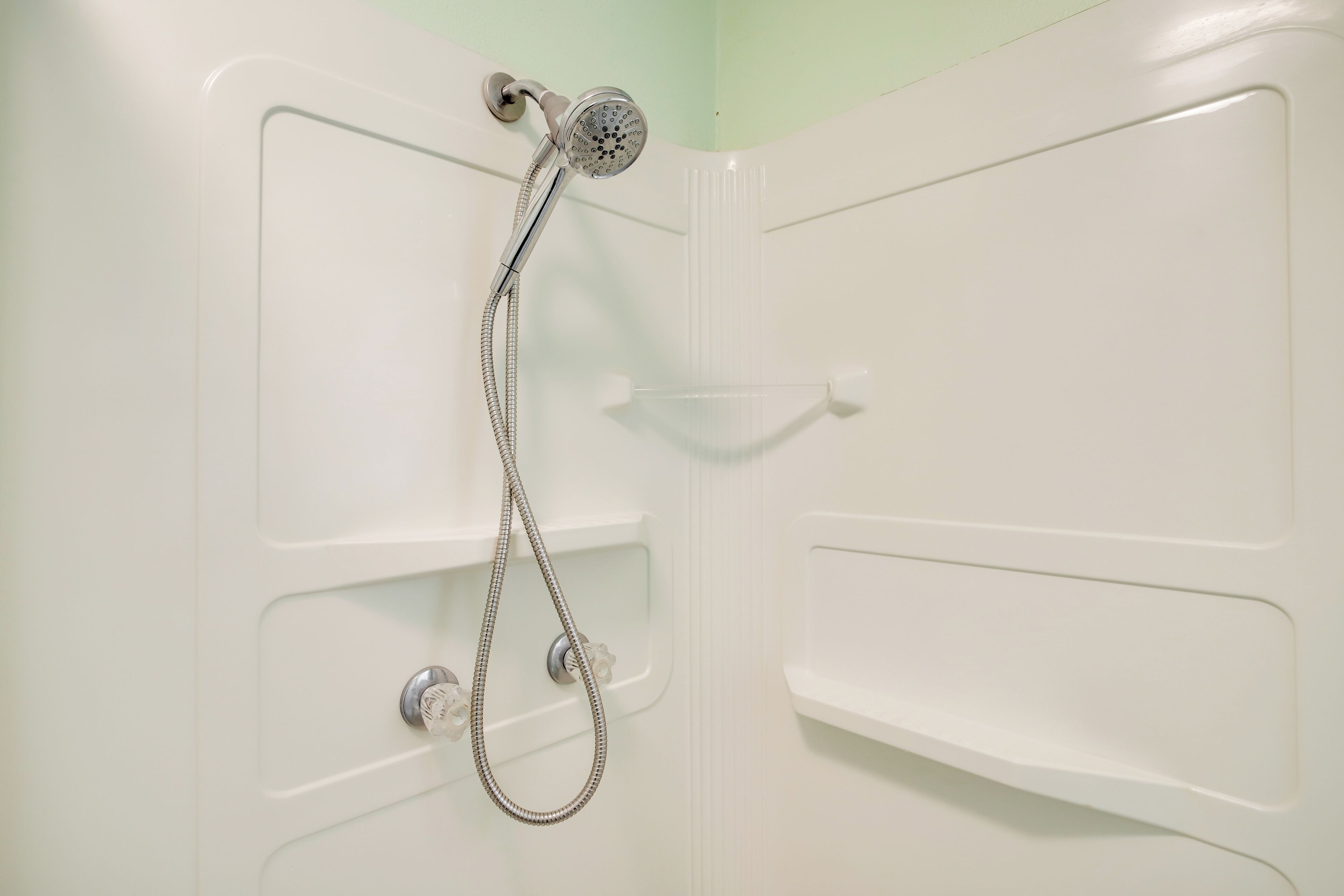Eine Dusche mit Duschkopf und Brauseschlauch.