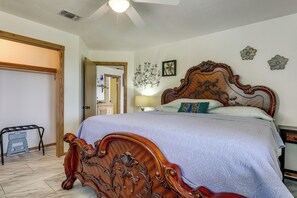 A bedroom with a wooden bed, a nightstand, a lamp, and a mirror. - Fredericksburg Retreat w/ Hot Tub, Patio & Views (Fredericksburg)