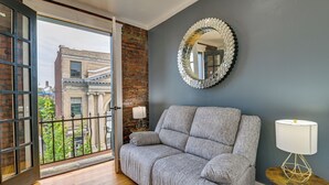 A room with a grey sofa, a round mirror, and a lamp on a small table. - 1 Mi to Falls View Park: Convenient Cohoes Retreat (Cohoes)