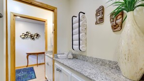 A bathroom with a granite countertop, a large vase, and decorative wall art. - Secluded Ozark Mtn Cottage w/ Wraparound Deck (Eureka Springs)