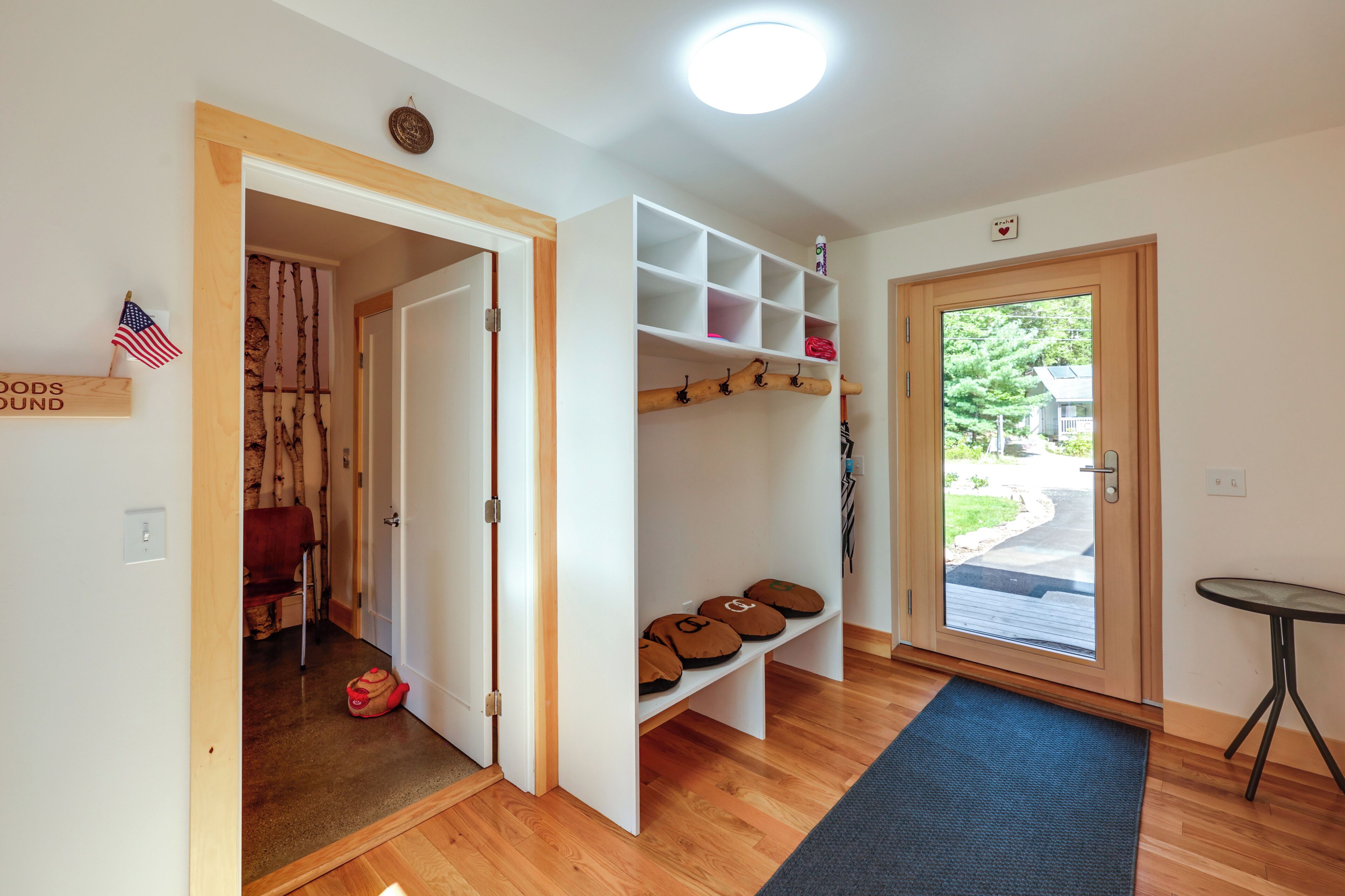A hallway with a wooden door, a shoe rack, and a small table.
