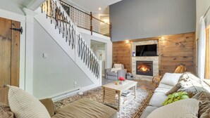 A spacious living room with a staircase, a fireplace, and a cozy seating area. - Private Hot Tub & Fire Pit: Pocono Lake House! (Pocono Lake)