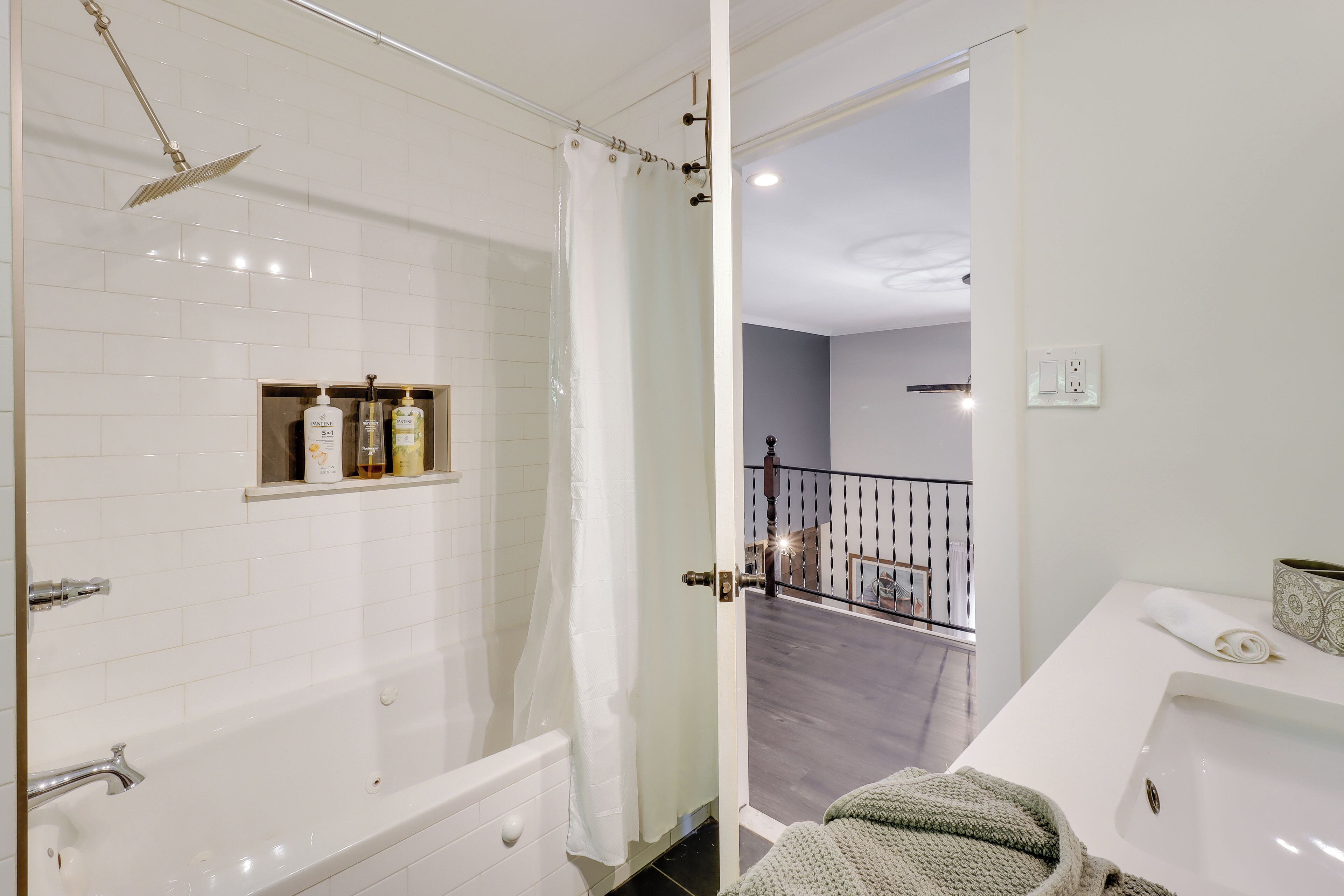 A modern bathroom with a bathtub, shower, and a white sink.