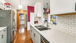 A modern kitchen with white cabinetry, a stainless steel refrigerator, a built-in oven, and a large island with a sink. - 3 Mi to Dtwn Yakima: Play & Stay in the Pnw! (Yakima)