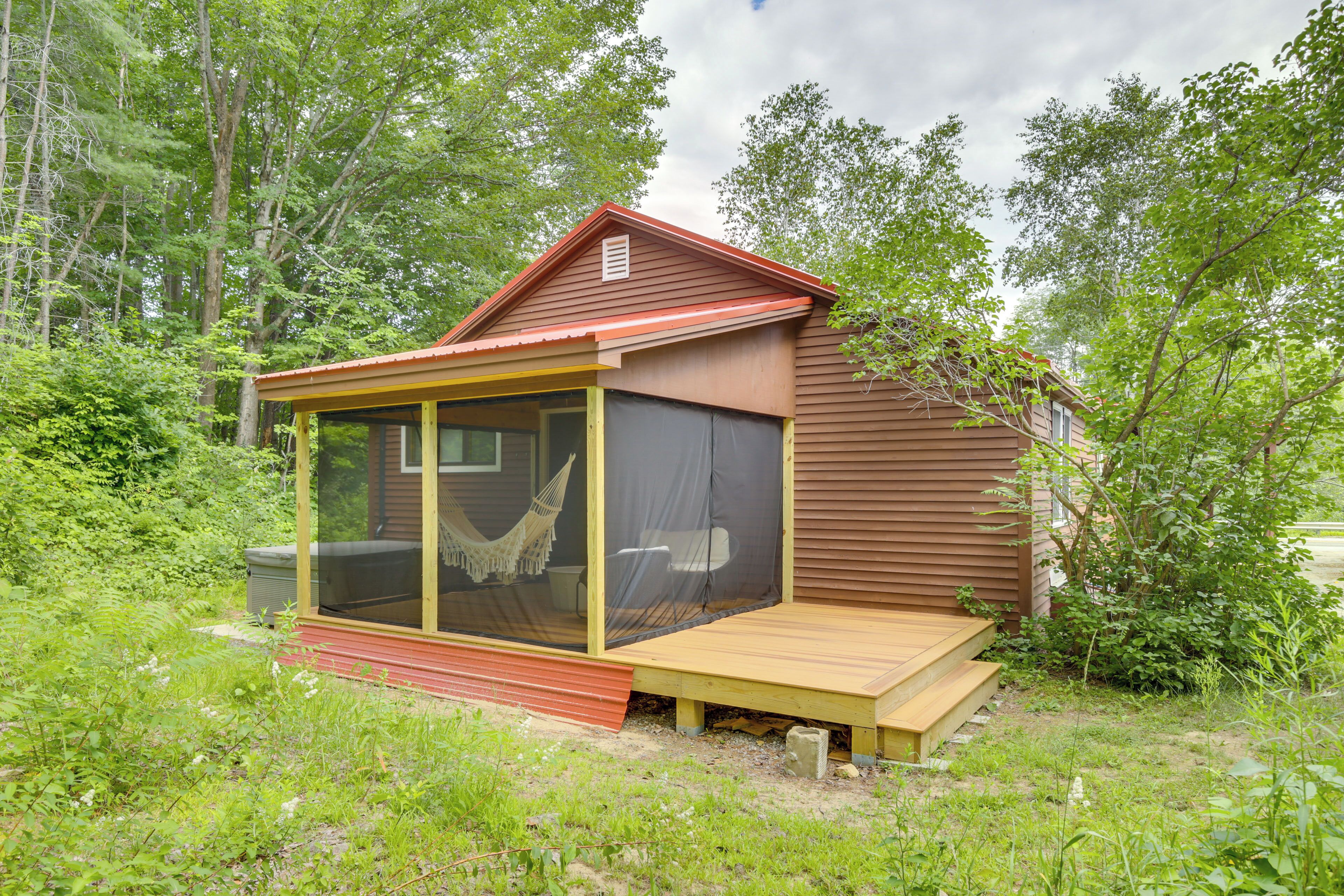 A small cabin with a screened porch and a hammock.