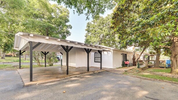 A covered outdoor area with a concrete floor, surrounded by trees. - Waterfront Home w/ Dock in South Grand Lake! (Vinita)