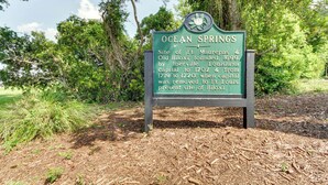 Un cartel histórico sobre Ocean Springs, que menciona su fundación y estatus de capital.