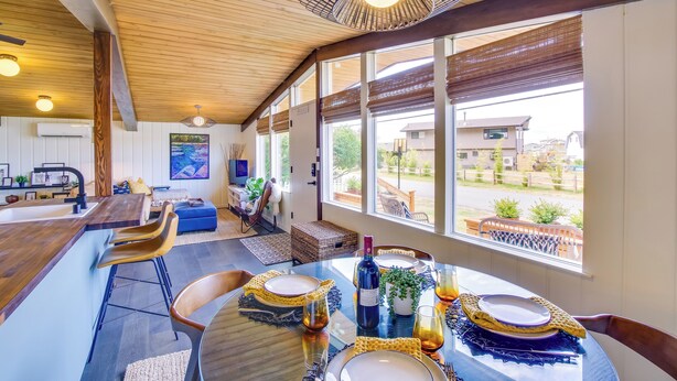 A dining area with a wooden ceiling, large windows, and a view of the outside. - Whidbey Island Oasis: Walk to Beach, Hot Tub, View (Greenbank)